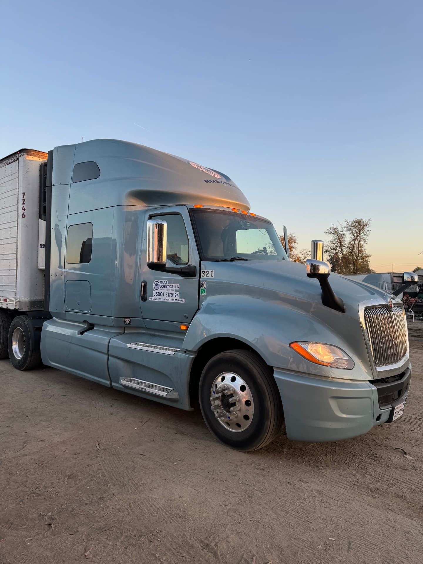 Maas Logistics International LT tractor hooked to a reefer trailer at dusk
